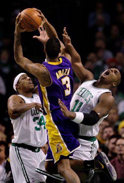 Trevor Ariza, center, fights for a basket in the latest Lakers-Celtics clash. (Associated Press / The Spokesman-Review)