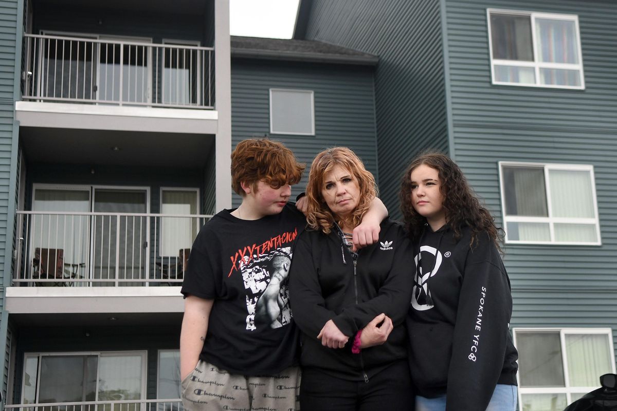 Diane Manns is photographed with her children, Adam Manns,14, left and Alexis Stojsic, 17, right in front of their Pope Francis Haven apartment in Spokane Valley on Tuesday, March 31, 2020. She and other tenants signed a voluntary termination notice and agreed to vacate by March 31, but because of the COVID-19 shutdown she can