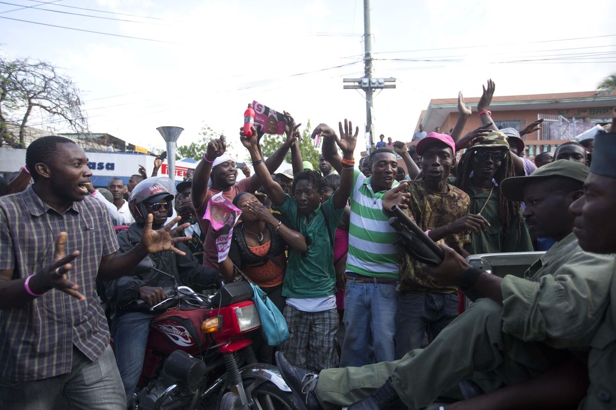 Government supporters cheer as armed members of Haiti’s disbanded army pass by during their protest to demand presidential elections in Port-au-Prince, Haiti, Friday, Feb. 5, 2016. (Dieu Nalio Chery / Associated Press)