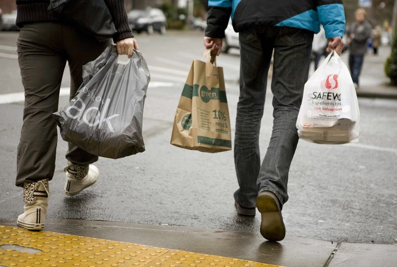 Shoppers carry paper and plastic bags in Portland.  (Associated Press)