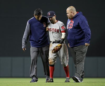 Boston Red Sox second baseman Dustin Pedroia, center, is assisted off the field after being injured by Manny Machado’s hard slide during the eighth inning of a game against the Baltimore Orioles on April 21, 2017. (Patrick Semansky / AP)