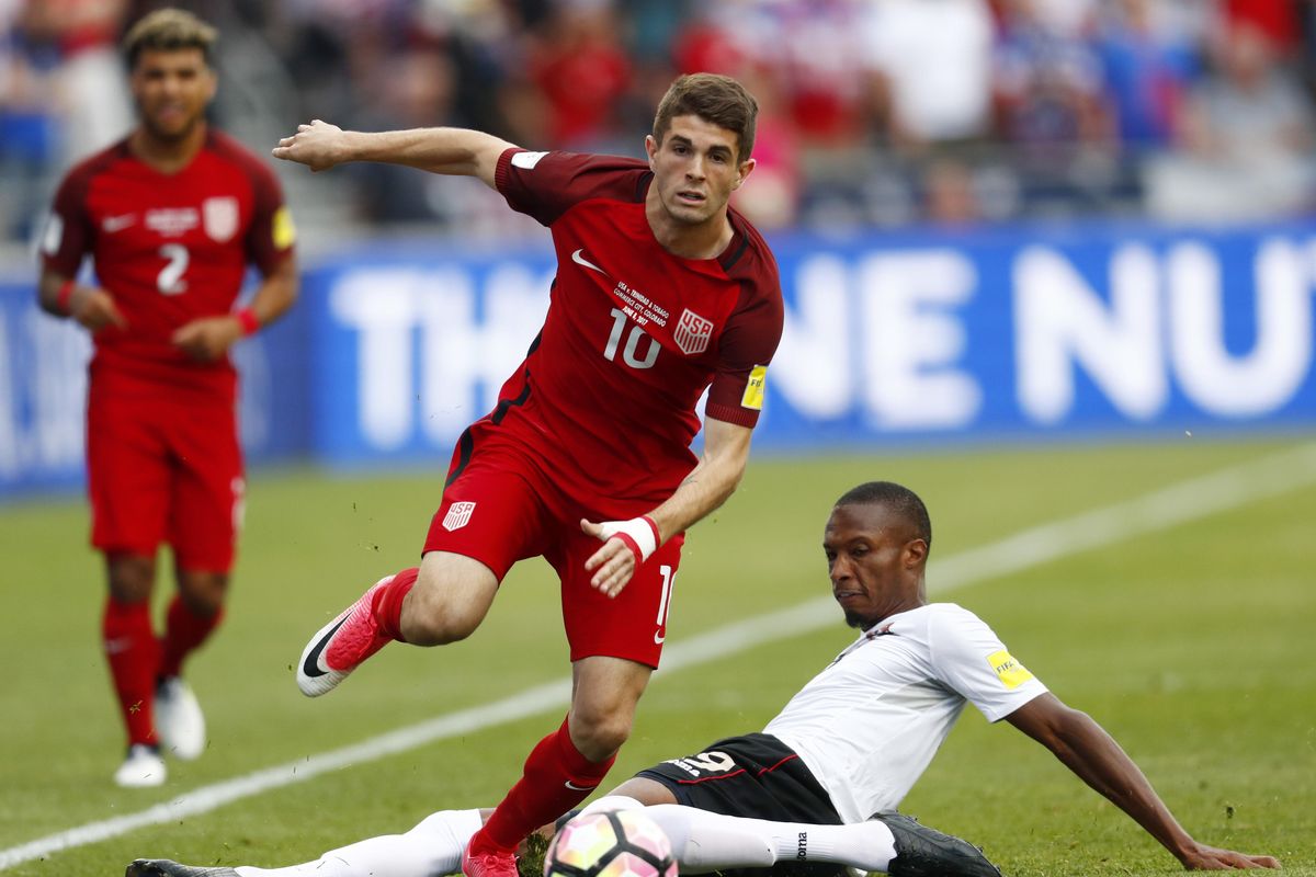 U.S. midfielder Christian Pulisic, front, jumps over Trinidad & Tobago forward Kenwyne Jones while pursuing the ball during the first half of a World Cup soccer qualifying match Thursday, June 8, 2017, in Commerce City, Colo. (David Zalubowski / Associated Press)