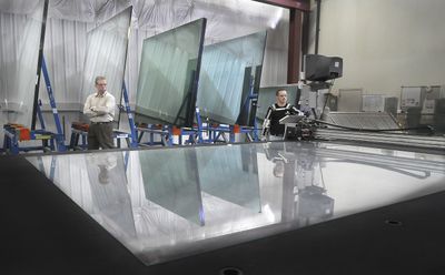 VPI Quality Windows CEO Michael Paquin, left, watches lead glass cutter Igor Maltsev use a computer-driven cutter to optimize use and minimize waste of a piece of glass at the Spokane window manufacturing plant. VPI engages all employees in the effort to conserve resources and cut waste.  (CHRISTOPHER ANDERSON / The Spokesman-Review)