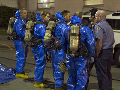 
Hazardous material specialists gather outside a University of Texas dormitory Friday evening, while investigating the presence of ricin. found by a student at the dorm. 
 (Associated Press / The Spokesman-Review)