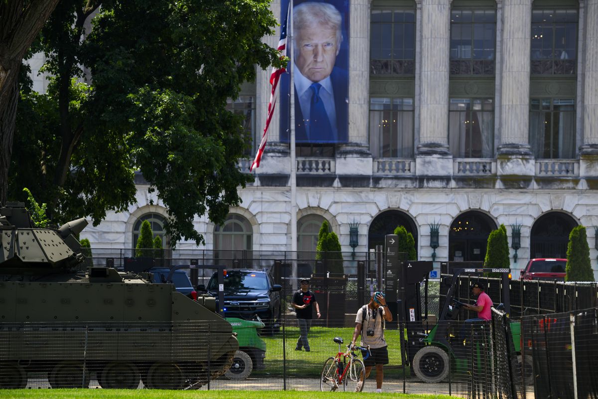 A banner featuring President Donald Trump hangs behind a Bradley fighting vehicle during preparations for Saturday’s Army parade on the National Mall on Thursday in Washington, D.C. (Pete Kiehart/For The Washington Post)