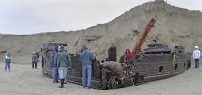 
Visitors check out the wooden hull of a shipwreck on Coos Bay's North Spit discovered after Pacific storms washed away much of the dune covering it. Local historians have no idea whose ship it was or when it ran aground. Associated Press photos
 (Associated Press photos / The Spokesman-Review)