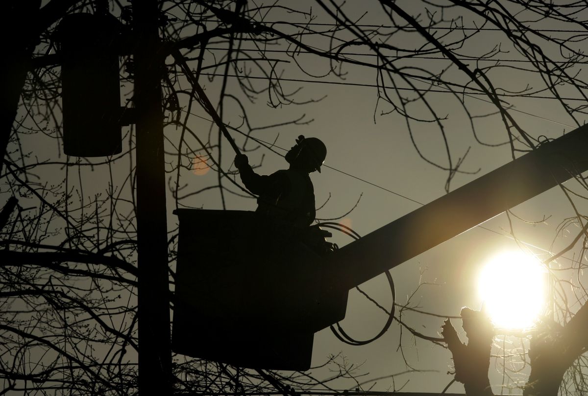 Donnie Peete, a lineman with Memphis Light Gas and Water, works to restore power Saturday in Mayfield, Ky. More than half a million homes and businesses remained without electricity. (Jeff Roberson / The Spokesman-Review)