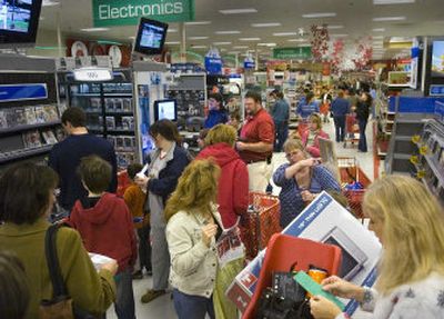 
Seth Campbell, executive team leader at the Target store in Northpointe Plaza, is surrounded by shoppers Friday as he answers questions and gives directions. 
 (Christopher Anderson / The Spokesman-Review)