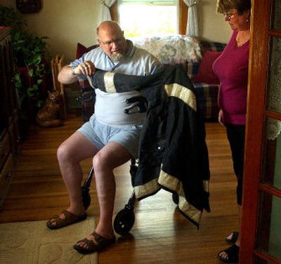 
David Sylvester and his wife, Carolyn, examine the burned fire-protection jacket he wore when injured last July 4. 
 (Jed Conklin / The Spokesman-Review)