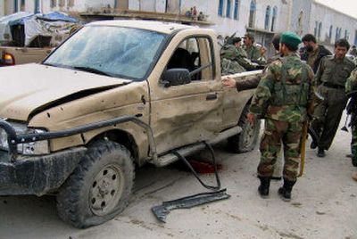 
Afghan troops examine a truck at the site of a bomb explosion in Kandahar on Monday. The bomb hit a convoy of Afghan army trucks loaded with troops, killing four. 
 (Associated Press / The Spokesman-Review)