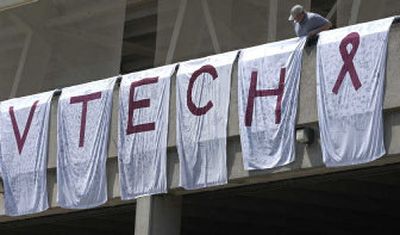 
A fan pauses to look at a display signed by Boston College students in memory of people affected by the Virginia Tech tragedy prior to a baseball game between the schools April 28 in Boston. 
 (Associated Press / The Spokesman-Review)