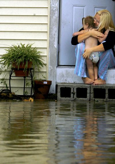 Dreann Smallwood, 22, hugs her daughter, Lillian Koeppen, on the front porch of their home Tuesday in Everglades City as the water recedes  after Tropical Storm Fay passed through southwest Florida.  (Associated Press / The Spokesman-Review)