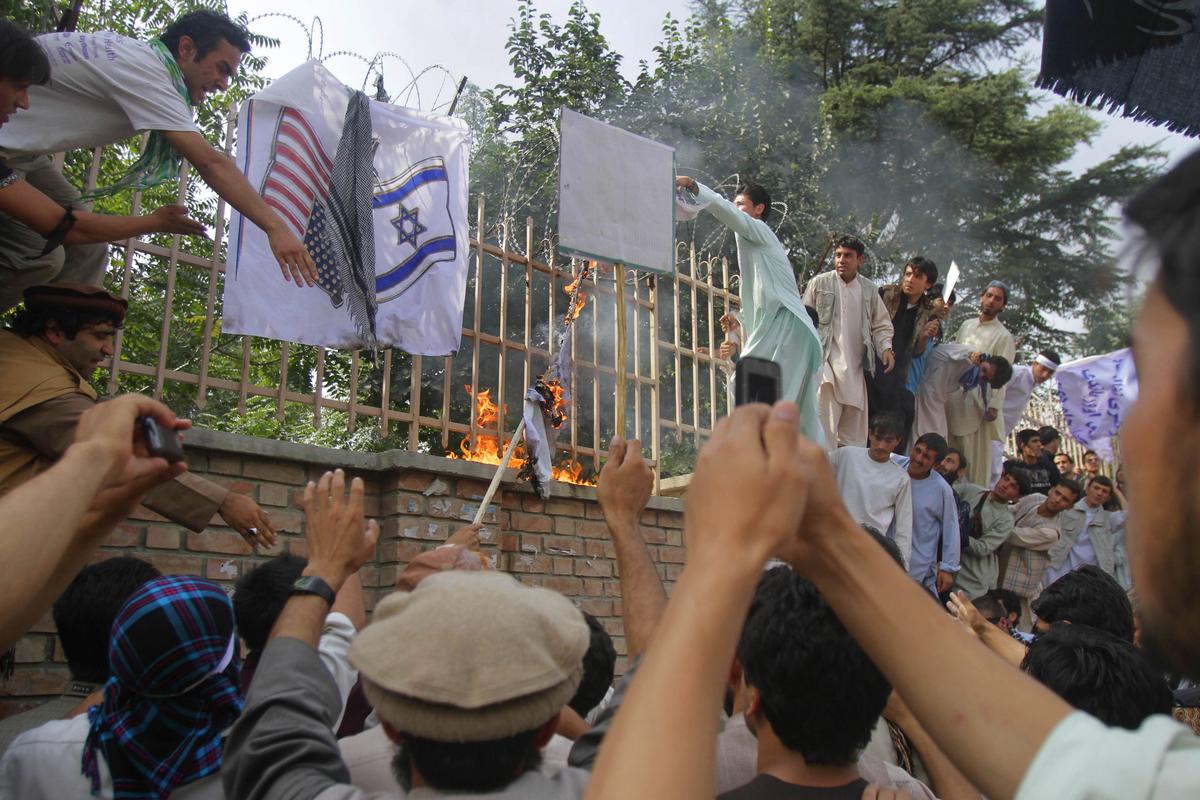 Afghans burn U.S. and Israeli flags in Kabul, Afghanistan, Sunday, Sept. 16, 2012 during a protest against an Internet video that mocks the Prophet Muhammad. The video sparked protests throughout the Muslim world and Afghan government blocked the YouTube site that hosts the video and its parent company, Google Inc., over the weekend in a move to prevent violent protests. (Ahmad Jamshid / Associated Press)