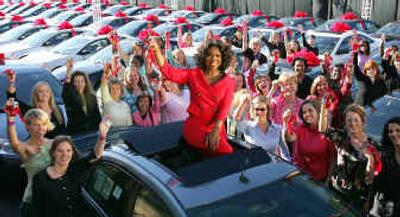 
Talk show host Oprah Winfrey sits atop a Pontiac G6 outside her Chicago studios Monday. She's surrounded by some of the 276 people from her audience who each received one of the cars at the start of the show to celebrate the premiere of her 19th season.
 (Associated Press / The Spokesman-Review)