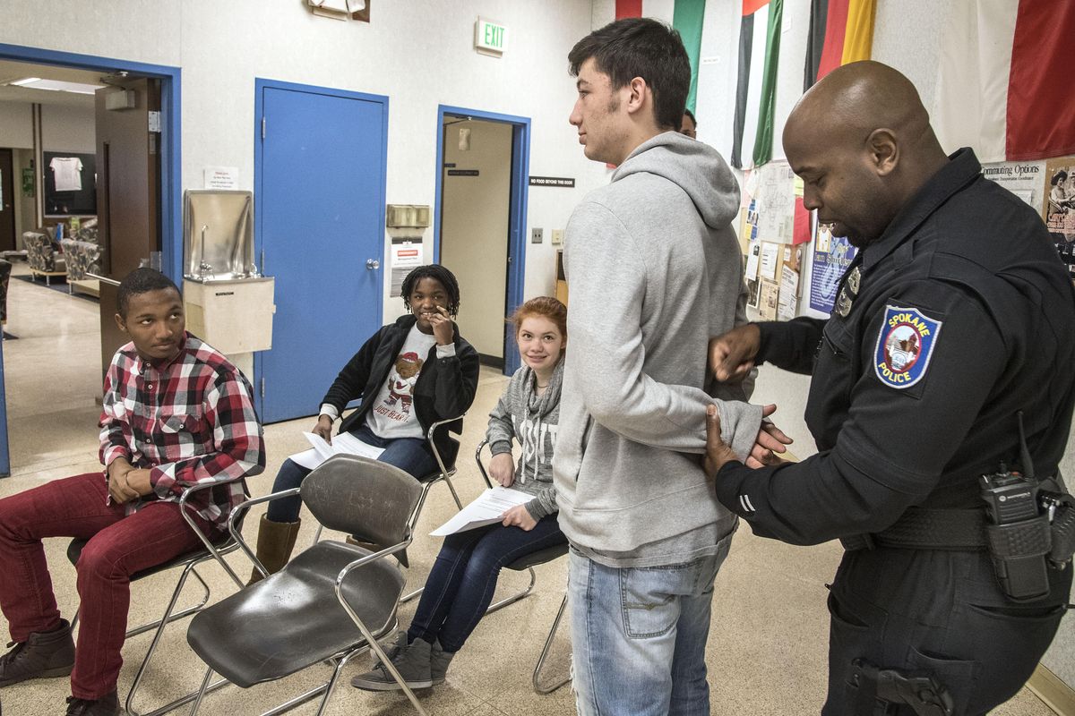 Spokane police Officer Winston Brooks rehearses a traffic stop and arrest scene Friday with North Central High School student Tyrone Neal during the Youth and Justice Forum at Spokane Falls Community College. (Dan Pelle / The Spokesman-Review)