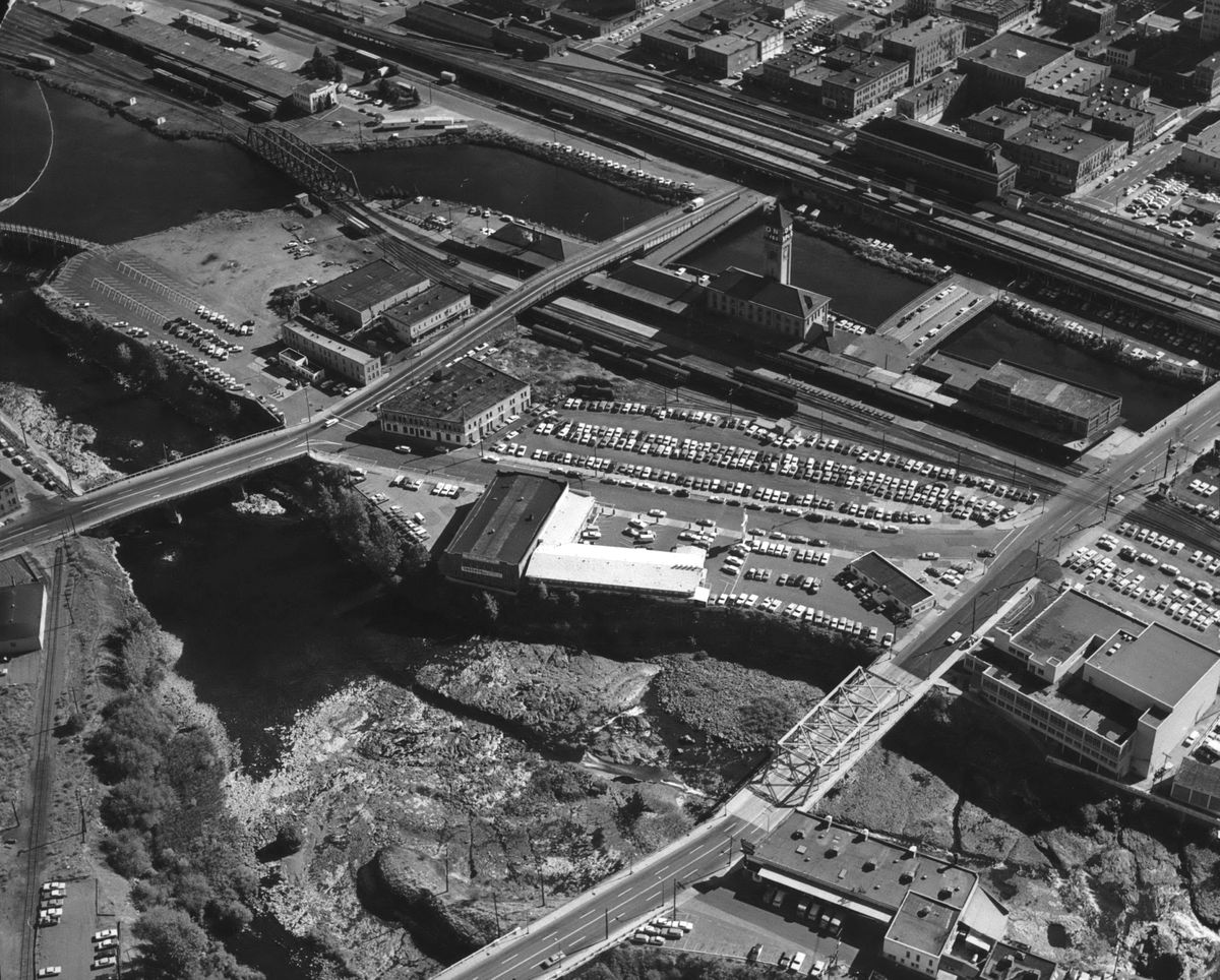 1969: Prominent in this aerial photo of downtown Spokane are the Great Northern Depot, with its iconic clock tower (upper center of the photo) and the Union Station (above and to the right of the clock tower), both symbols of the railroads that were key to Spokane’s prominence from the 1880s and the early 20th century. Among the buildings still visible on Havermale Island, situated in the middle of the Spokane River, are the former Travelodge motel with the white roof in the center, the former YMCA at lower right, and the Railway Post Office at center right, just west of the Great Northern Depot.  (THE SPOKESMAN-REVIEW PHOTO ARCHIVES)