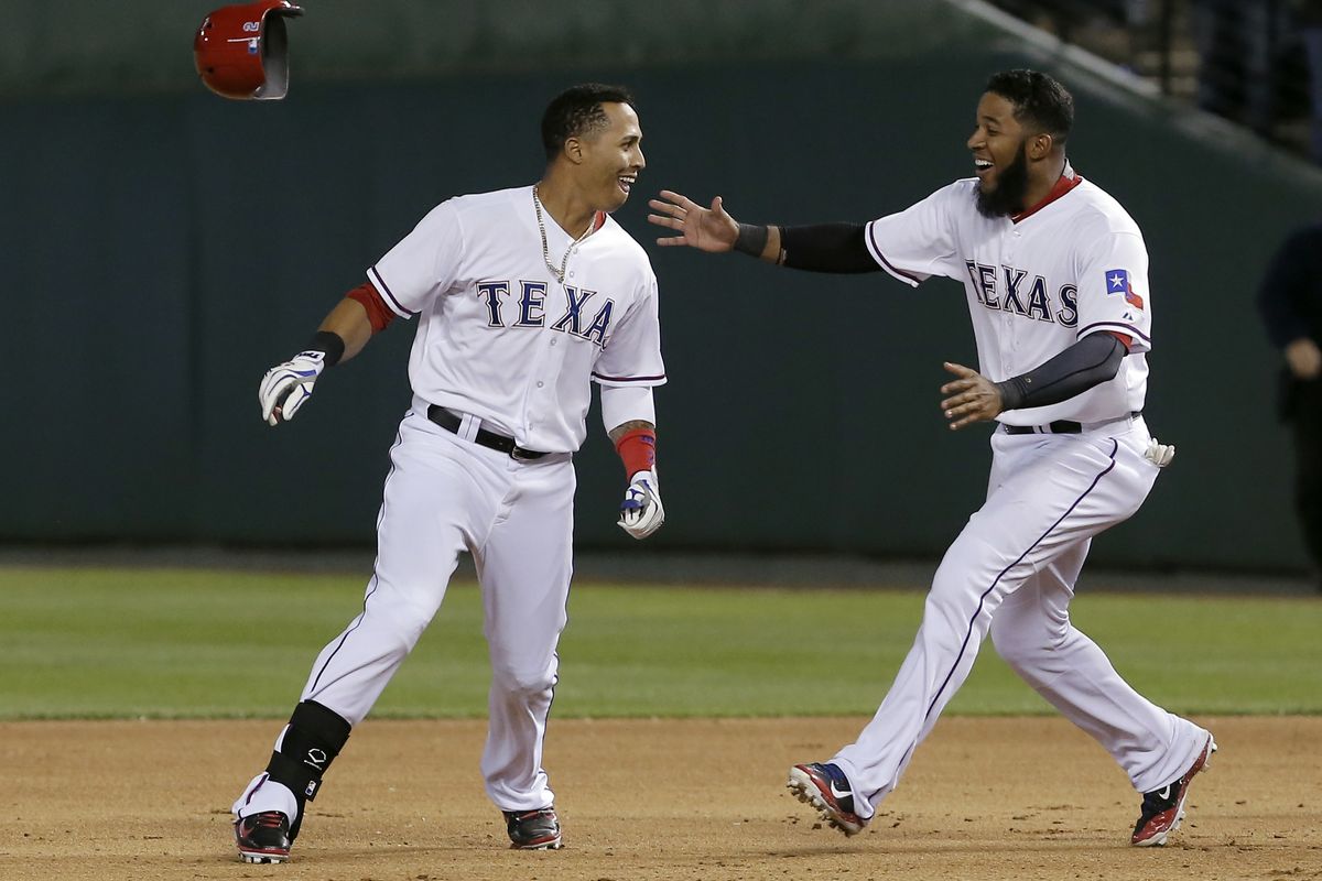 Texas’ Elvis Andrus, right, congratulates Leonys Martin after his winning single in the ninth inning. (Associated Press)