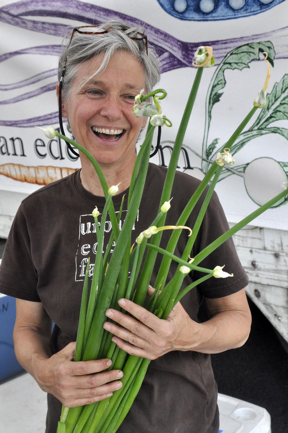Tarawyn Waters of Urban Eden Farms holds green onions during the Night Market at Kendall Yards in this file photo. (Adriana Janovich / The Spokesman-Review)