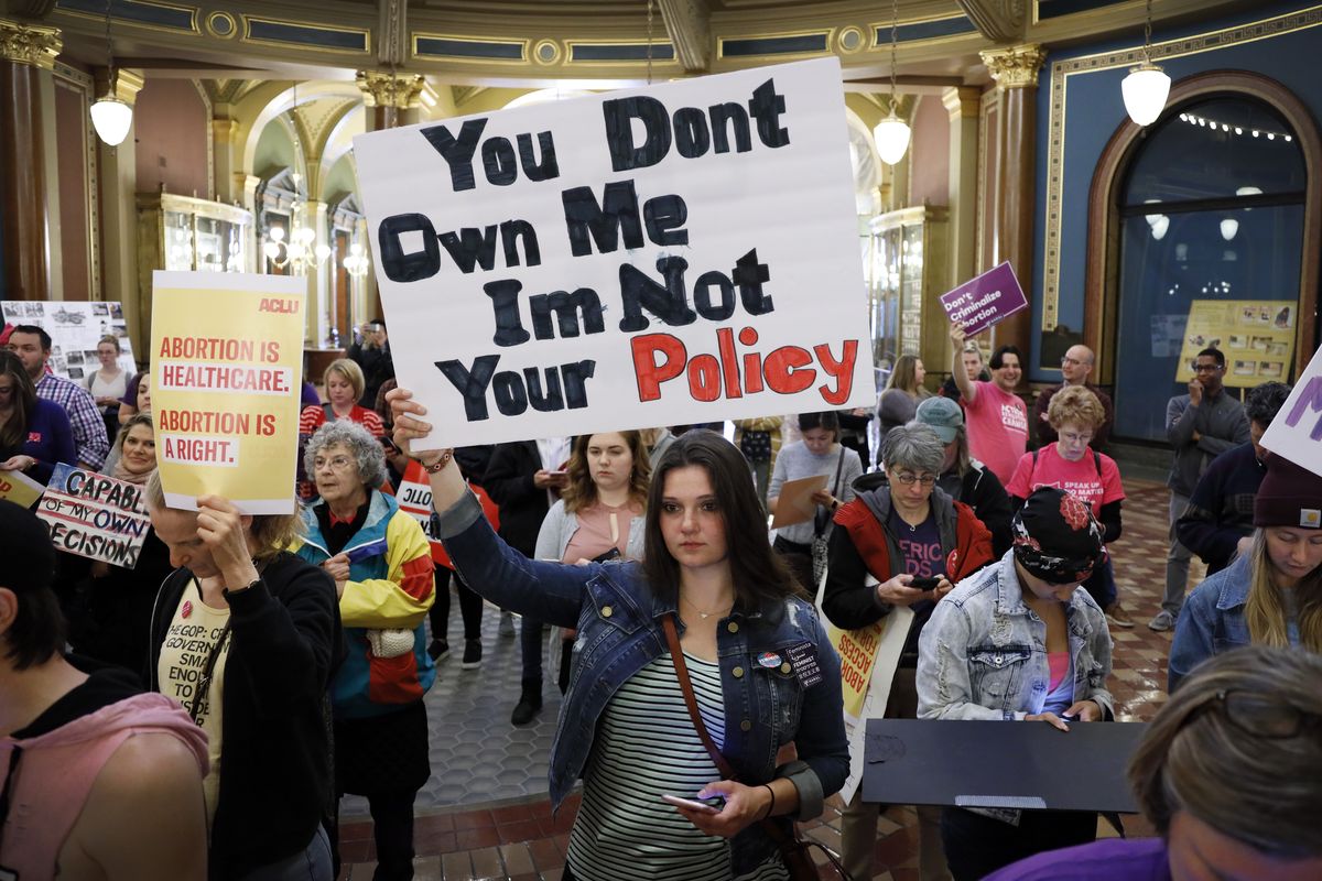 FILE - Marissa Messinger, of Lake View, Iowa, center, holds a sign during a rally to protest recent abortion bans, May 21, 2019, at the Statehouse in Des Moines, Iowa. With a devoutly anti-abortion Republican governor and large GOP legislative majorities, Iowa would seem poised to easily ban abortion if the U.S. Supreme Court overturns Roe v. Wade.  (Charlie Neibergall)
