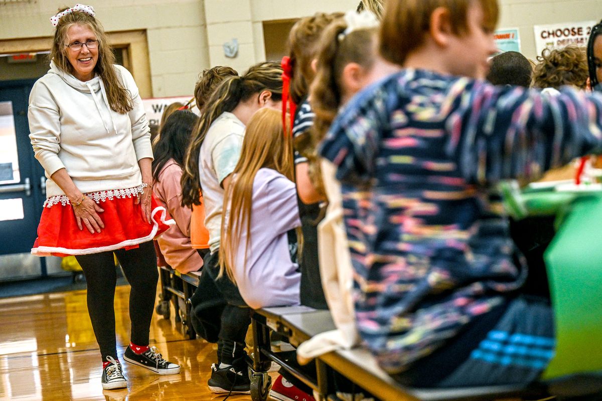 Ness Elementary volunteer Cindy Akins watches over the students as they make gingerbread houses at the school in West Valley on Dec. 18.  (Kathy Plonka/The Spokesman-Review)