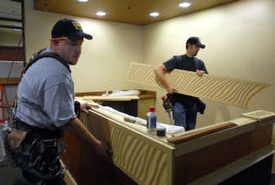 
Steve Smith Jr., left, and Mike Link of Goebel Construction fit decorative panels on the reception desk in the office suite being prepared for Evans, Craven and Lackey in the Lincoln Building in downtown Spokane on Thursday. 
 (Photos by Jesse Tinsley / The Spokesman-Review)