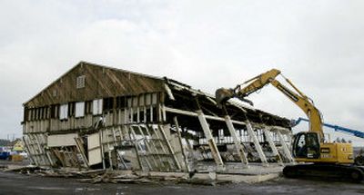 
An old building is gently pushed down instead of being demolished at Fort Lewis on Monday to avoid damaging valuable beams and other material in the building. 
 (Associated Press / The Spokesman-Review)