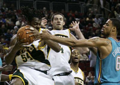 
Chris Wilcox rips down a rebound for Seattle against teammate Nick Collison and New Orleans' Tyson Chandler. 
 (Associated Press / The Spokesman-Review)