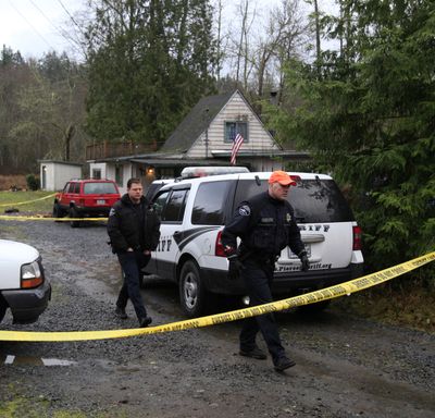 Pierce County sheriff’s deputies walk away Tuesday from the rural home where two  deputies were shot Monday night near Eatonville, Wash.  (Associated Press)