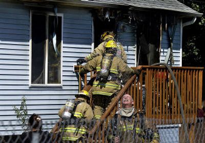 
Spokane Valley firefighters enter a burned-out home at 2708 N. Park Road  Wednesday. Residents of the home state the fire started in the basement and spread quickly to the main level. All four people got out safely. 
 (Liz Kishimoto / The Spokesman-Review)