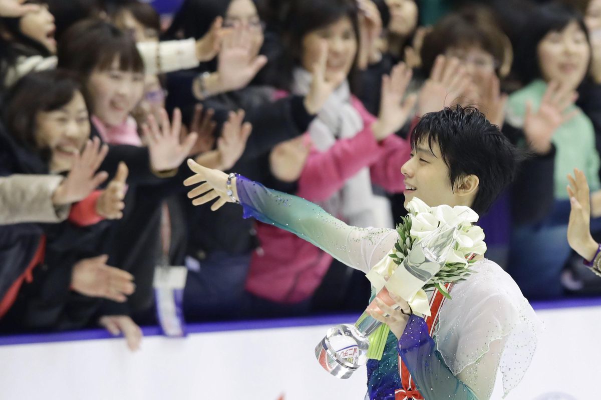 Olympic champion Yuzuru Hanyu waves at fans after winning the NHK Trophy in Sapporo, northern Japan, Saturday, Nov. 26, 2016. Hanyu topped the 300-point mark to win the NHK Trophy and qualify for the figure skating Grand Prix Final. (Hiroki Yamauchi / Kyodo News via AP)