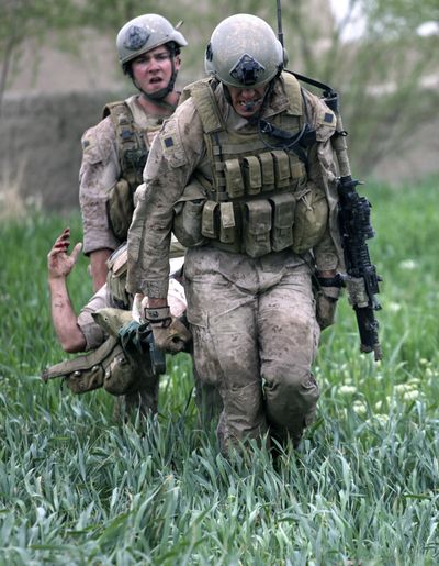 U.S. Marines carry a wounded fellow Marine across a field to a U.S. Army medevac helicopter, during a firefight in Helmand province, Afghanistan, on March 2.  (Associated Press)