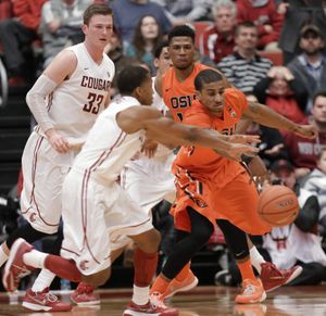 WSU’s Ny Redding and Oregon State’s Gary Payton II, right, fight for a loose ball in the second half Saturday. (Associated Press)