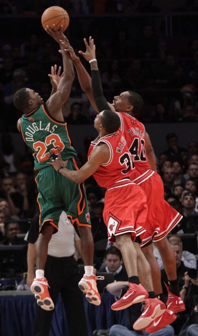 Knicks guard Toney Douglas (23) shoots over the Bulls’ C.J. Watson (32) and Kurt Thomas. (Associated Press)