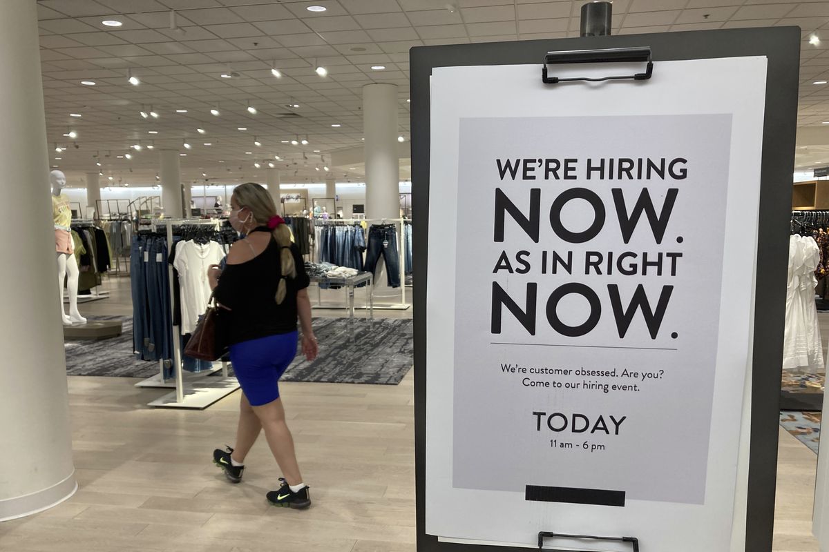 A customer walks behind a sign at a Nordstrom store seeking employees, Friday, May 21, 2021, in Coral Gables, Fla. The number of Americans seeking unemployment benefits dropped last week to 406,000, a new pandemic low and more evidence that the job market is strengthening as the virus wanes and economy further reopens. (Associated Press)