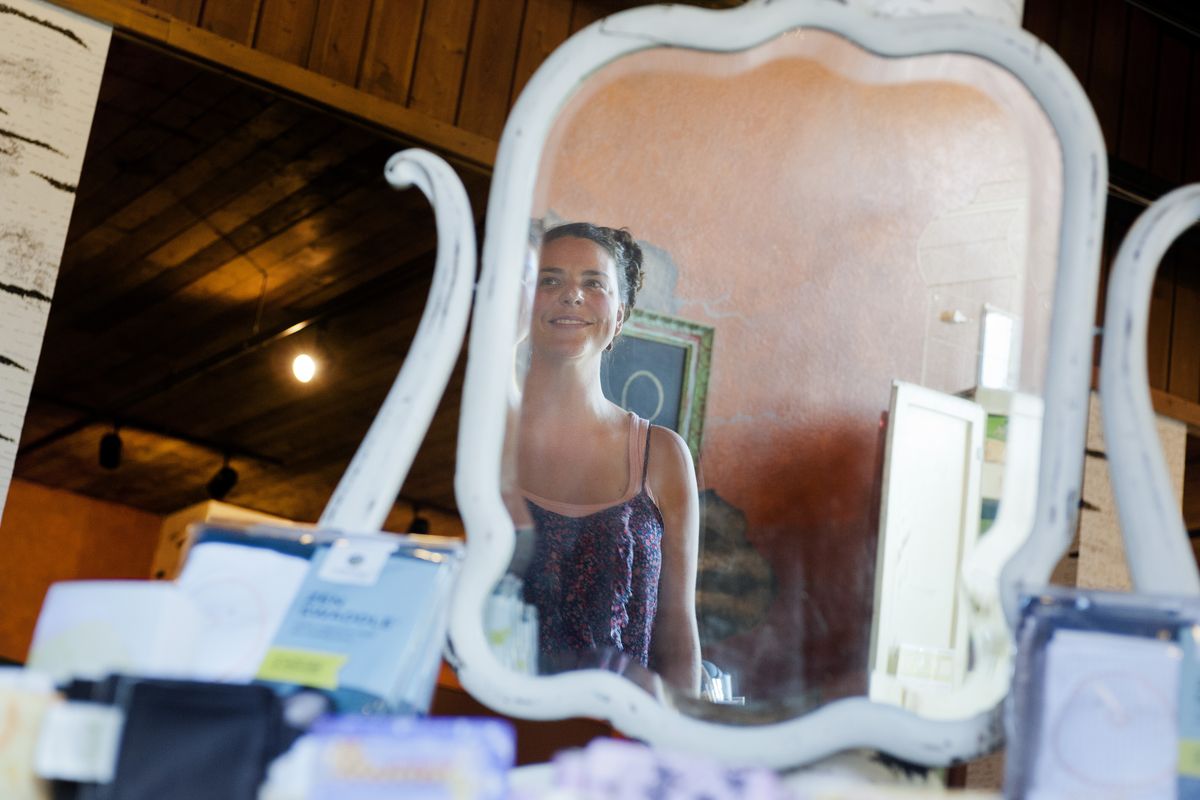 Heather Villa is seen reflected in a mirror as she gives a tour of her store, Bella Cova, in Spokane. (Tyler Tjomsland)