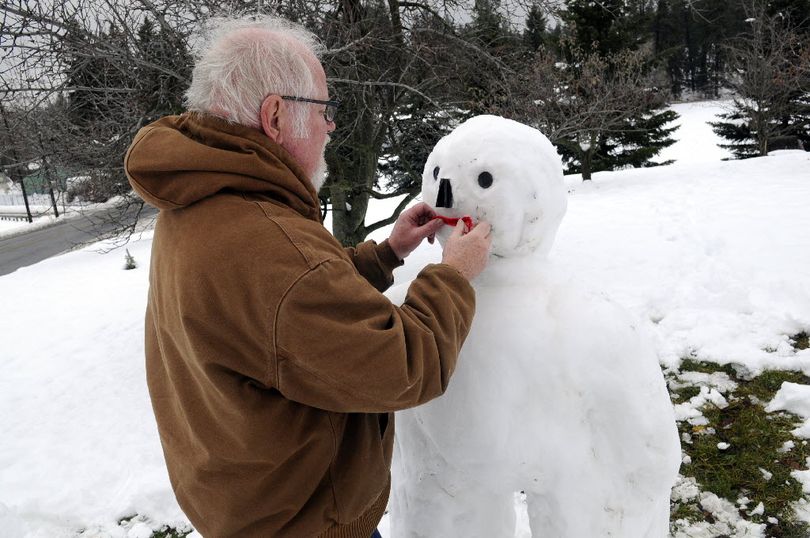 Jerry Stout puts the finishing touches on his snowman he built in his Upriver Drive apple orchard, Thurs., Dec. 2, 2010. 