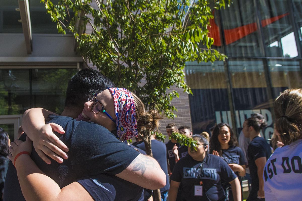 Nike employee Emma Keller, of Deer Park, hugs a fellow employee during the grand opening of Nike Factory Store in downtown Spokane on Thursday, June 14, 2018. (Kathy Plonka / The Spokesman-Review)