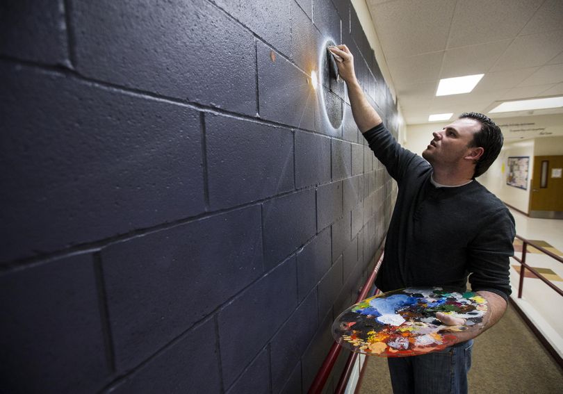 In this May 17, 2017 photo, local artist Jason Sanchez paints a galaxy mural in the front hallway of Ramsey Magnet School of Science in Coeur d'Alene, Idaho. Sanchez, a disabled Army veteran, has been spending several hours each weeknight since mid-April to complete the solar system mural at no cost to his childhood school. He plans to have it done in early June. (Loren Benoit/Coeur D'Alene Press via AP) ORG XMIT: IDCOE101 (Loren Benoit / AP)