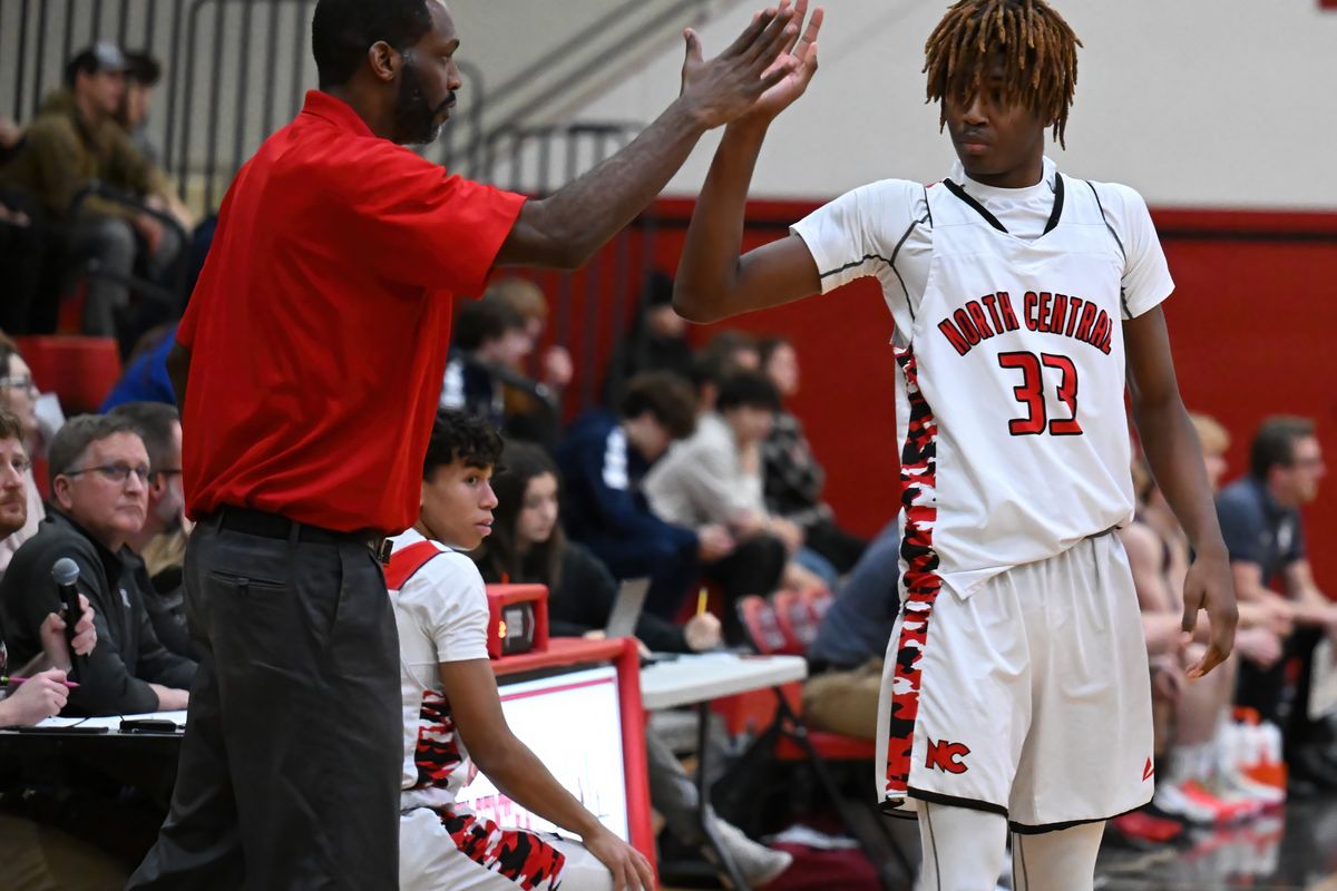 North Central boys basketball coach Andre Ervin gives his son, center Jacori Ervin, a high-five during Tuesday’s Greater Spokane League game with visiting Mt. Spokane.  (Colin Mulvany/The Spokesman-Review)