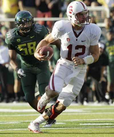 Stanford quarterback Andrew  Luck scrambles before scoring as Oregon defensive end Kenny Rowe chases during the first quarter of an NCAA college football game Saturday, Oct. 2, 2010, in Eugene, Ore. (Associated Press)