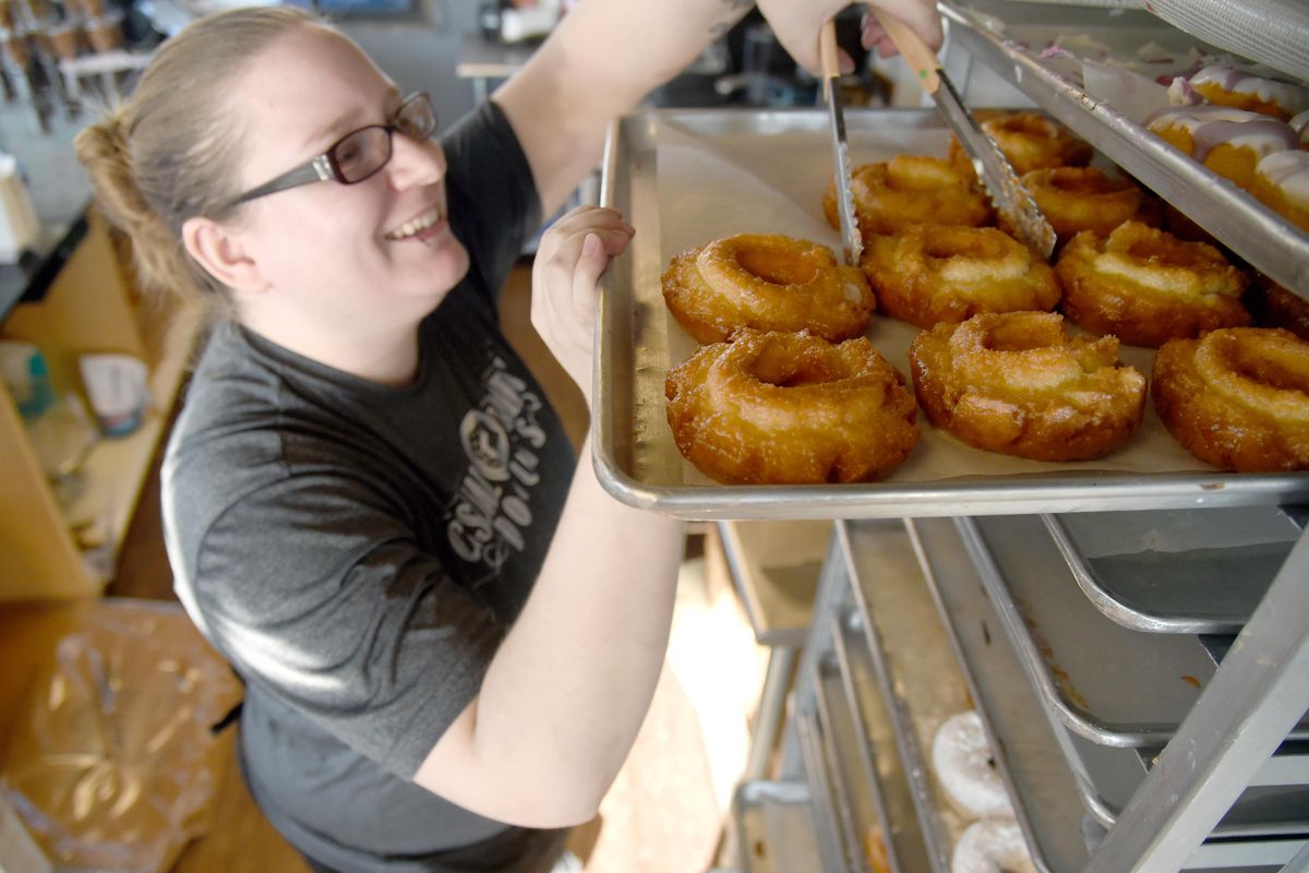 Leslie Knapp, manager of Casual Friday Donuts on North Division Street,  fills a dozen-doughnut order for a customer Saturday. Casual Friday stayed open during the power outage, using a generator and gas-powered appliances. (Jesse Tinsley / The Spokesman-Review)