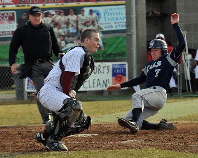 Mt. Spokane’s Spencer Mallonee slides home to score Thursday as University catcher Hayden Powell attempts to corral the throw home. (Jesse Tinsley)
