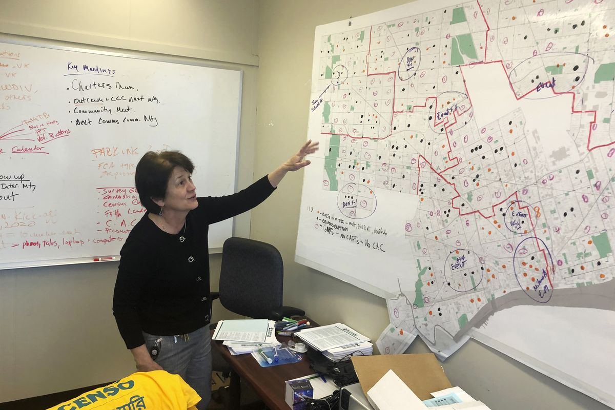In this Nov. 22, 2019 file photo, Detroit 2020 Census Campaign executive director Victoria Kovari looks over a Detroit map showing city neighborhoods that were under-counted in the 2010 census. Michigan's slow population growth over the past decade will cost the state a U.S. House seat, continuing a decades-long trend as job-seekers and retirees have fled to other states.  (Corey Williams)