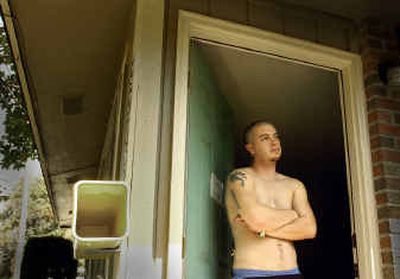 
Justin Eyre stands in the doorway of his house on North Madelia reflecting on the Monday night visit by friends John E. Lipinski and Melissa S. Saldivar.
 (The Spokesman-Review)