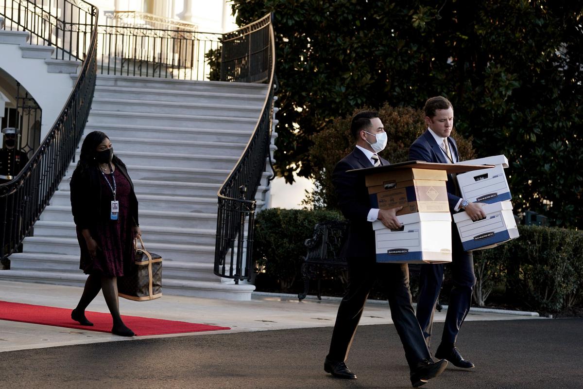 Aides move boxes out of the White House as President Donald Trump prepares to board Marine One on the last day of his first term as president in Washington, D.C. on Jan. 20, 2021. (New York Times)