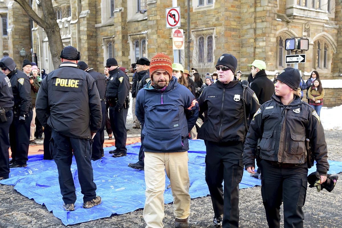 John Lugo, center, of Unidad Latina en Accion of New Haven, is arrested during a demonstration after some protesters blocked the intersection of Elm and College Streets in New Haven, Conn., Friday, Feb. 10, 2017, and refused to move. The protesters were in favor of changing the name of Yale University’s Calhoun College. The peaceful arrests were preplanned and coordinated between the demonstrators and New Haven police. (Peter Hvizdak / New Haven Register)