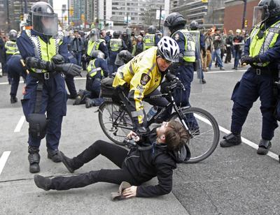 Protesters clash with police in downtown Vancouver on Saturday.  (Associated Press)