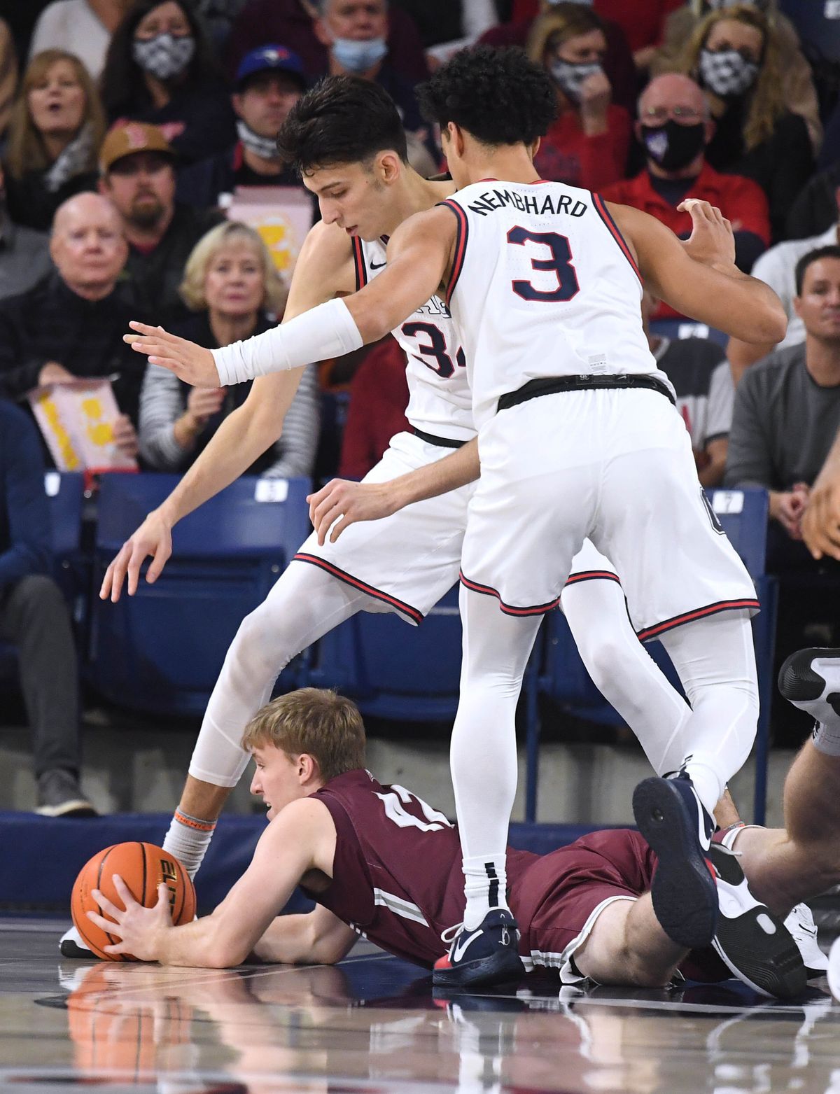 Gonzaga center Chet Holmgren (34) and Gonzaga guard Andrew Nembhard (3) tower over Bellarmine forward Curt Hopf (42) as he scrambles for a loose ball during the first half of an NCAA college basketball game, Friday, Nov. 19, 2021, in the McCarthey Athletic Center.  (COLIN MULVANY/THE SPOKESMAN-REVIEW)