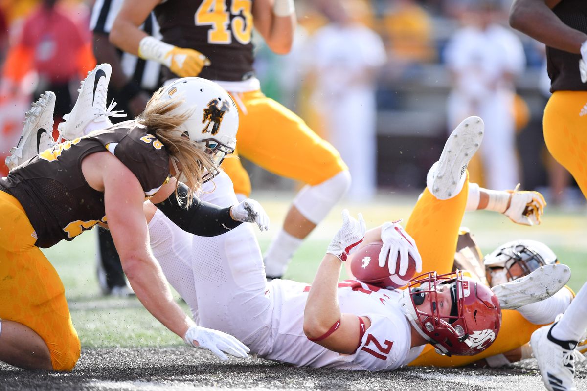 Washington State Cougars running back Max Borghi (21) lands in the end zone for a touchdown against Wyoming during the second half of a college football game on Saturday, September 1, 2018, at War Memorial Stadium in Laramie, Wyo. WSU won the game 41-19. (Tyler Tjomsland / The Spokesman-Review)
