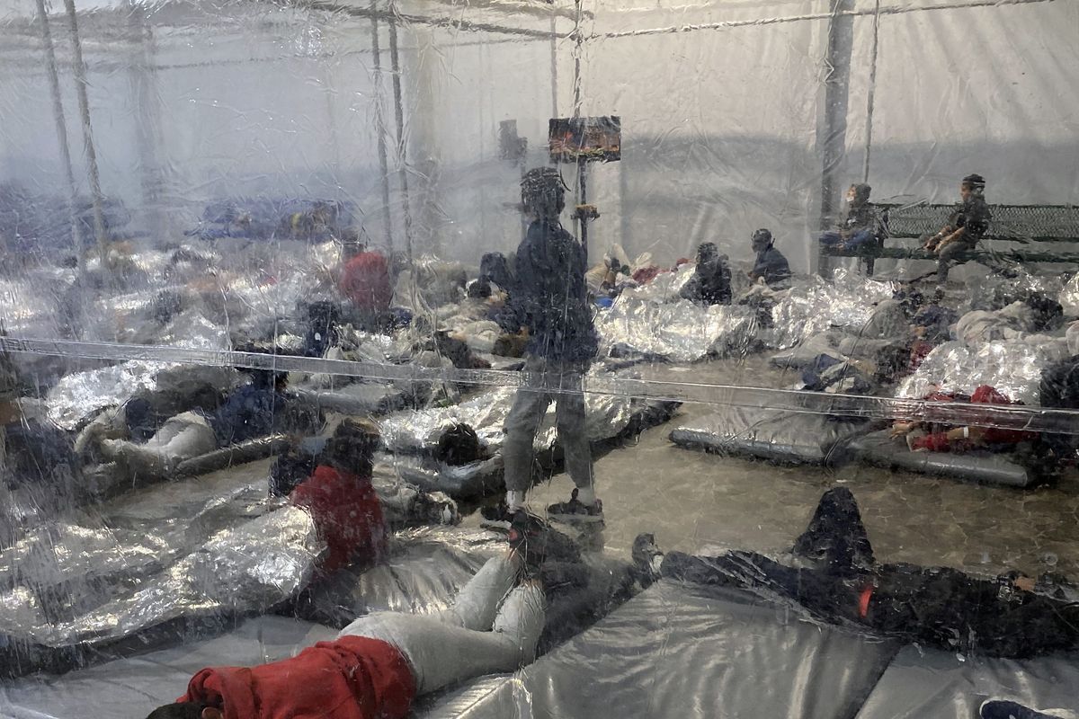 This March 20, 2021, photo provided by the Office of Rep. Henry Cuellar, D-Texas, shows detainees in a Customs and Border Protection (CBP) temporary overflow facility in Donna, Texas. President Joe Biden